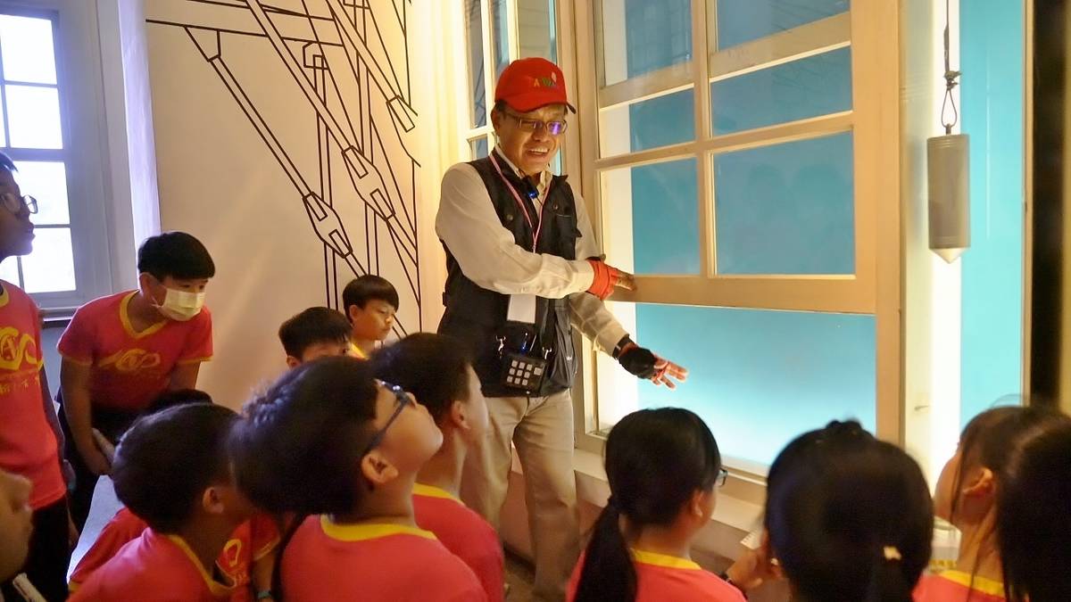 導覽老師介紹原臺南州廳建築特色的上下開木窗及通風口(文化部提供)