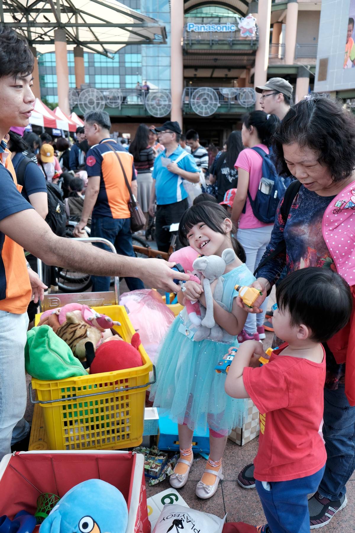 小朋友跟著家人來到在耶誕跳蚤市場，挑選到她心愛的娃娃臉上充滿著幸福洋溢。