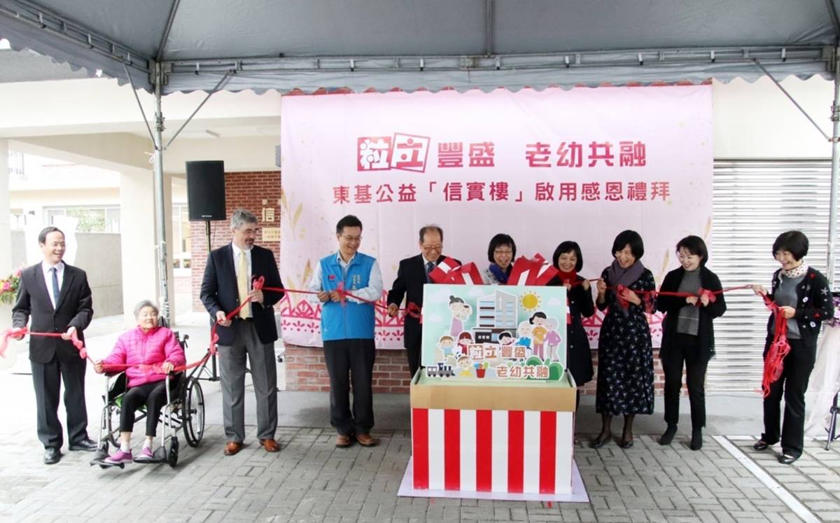 東基公益信實樓啟用，邀請與會來賓與老人日間照顧中心代表一起打開象徵老幼和樂共融的「禮物盒」。
