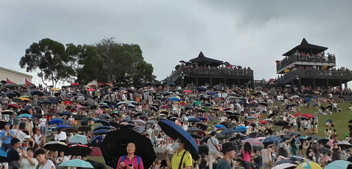 在等待閉幕過程中，天空漂下細雨，形成一片傘海的畫面。