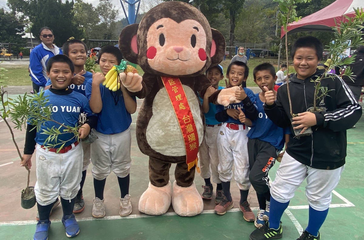 桃源國小棒球隊小選手們領到苗木，開心的跟林管處吉祥物「猴塞雷」一起合影。
