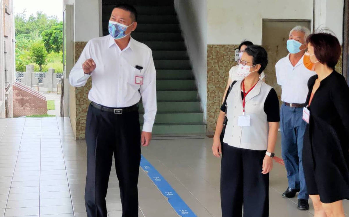 典試委員周蓮香(前排中)在縣府秘書長盧協昌等人陪同下，巡視考場。