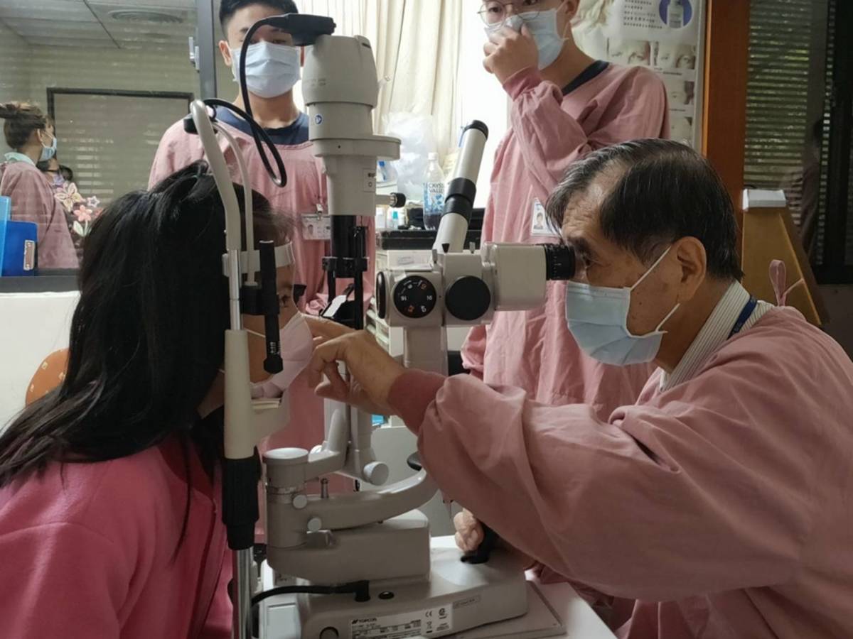 許明木醫師為學童檢查視力