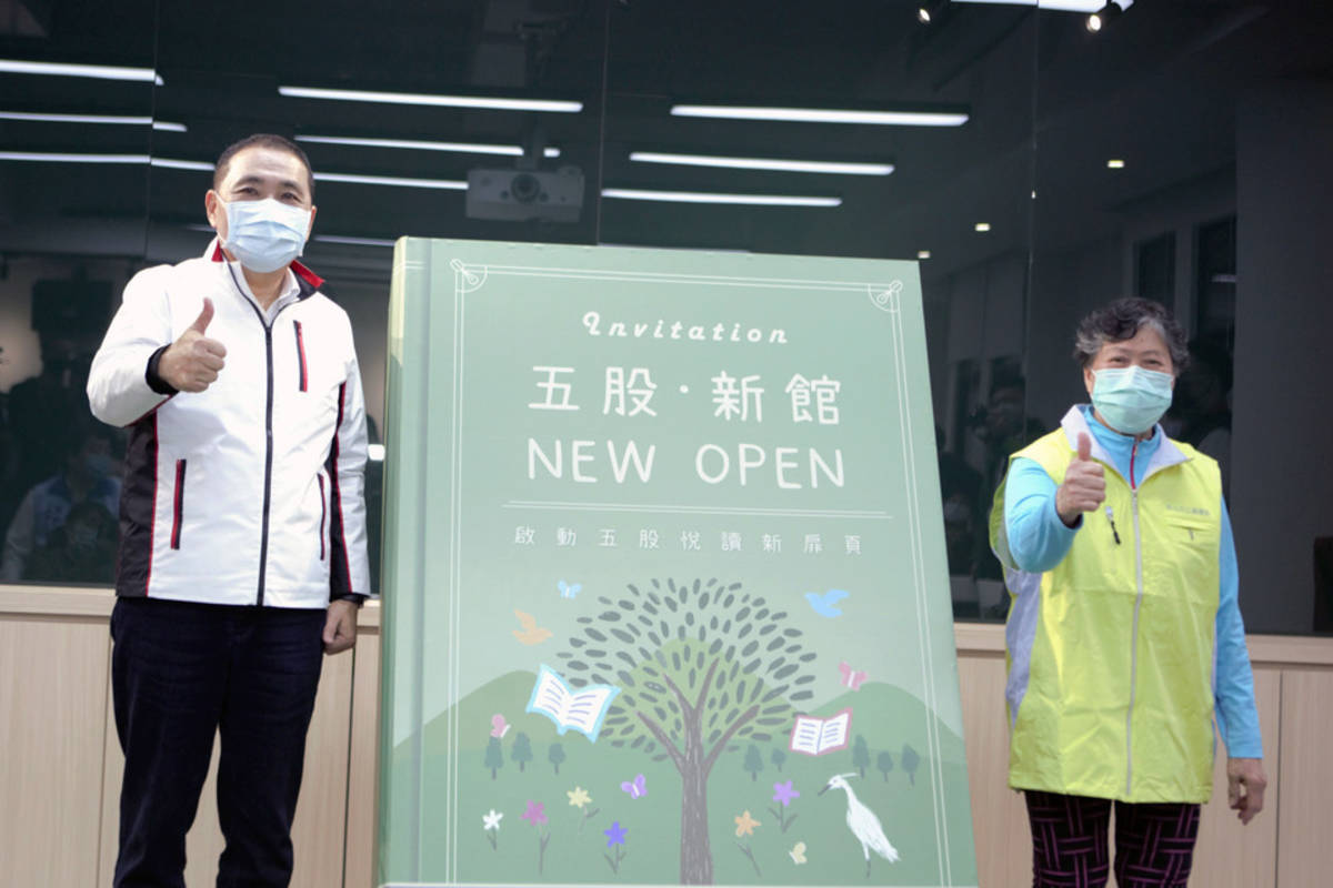 新北市長侯友宜與五股分館的資深志工一起揭開大書象徵五股分館啟用 (新北市圖提供)