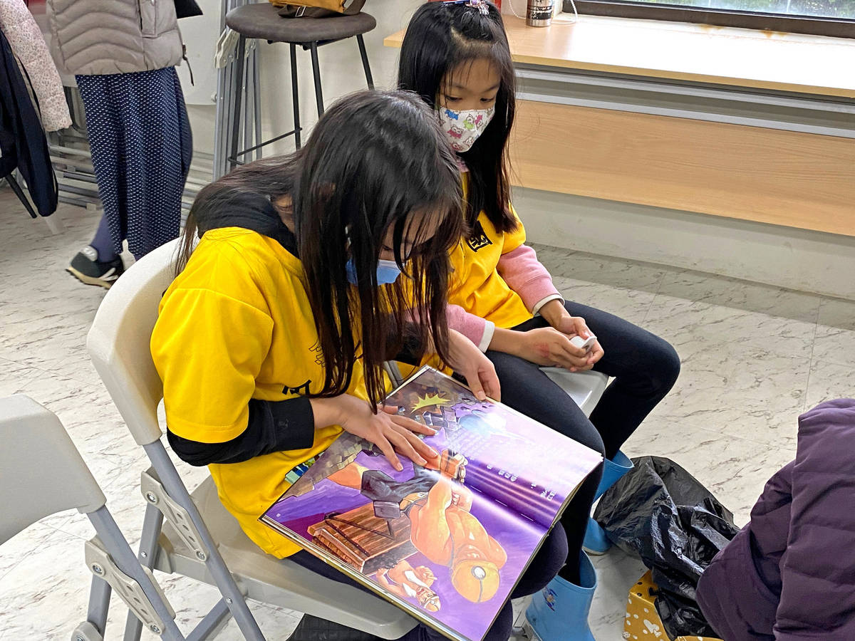 瓜山國小同學仔細端詳自己所創作的「小金的奇妙歷險」繪本