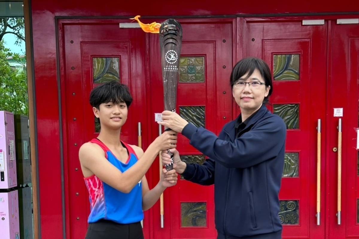全國原住民族運動會聖火傳抵臺東縣，由縣府教育處副處長黃玉燕(右)代表迎接聖火，再轉交寶桑國中田徑隊員接續傳遞。