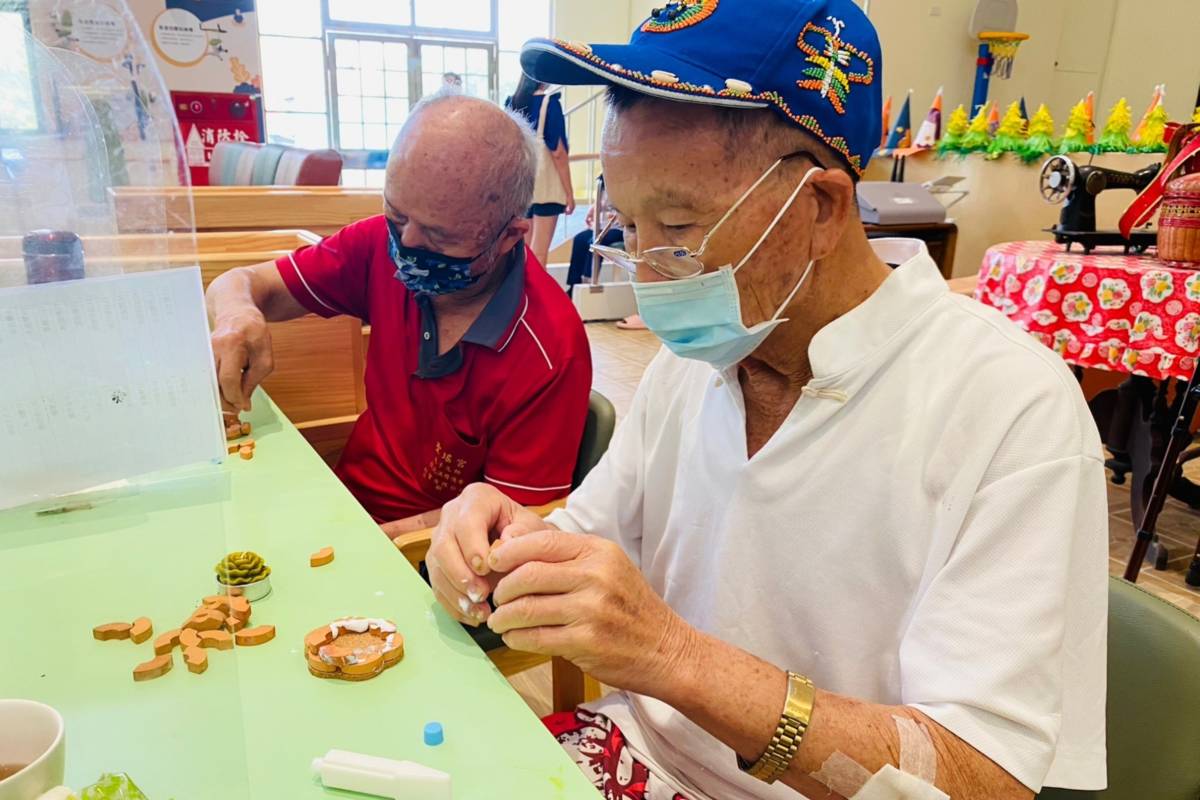 長輩小心翼翼用紅磚積木搭出作品(圖片來源：秀和苑提供)