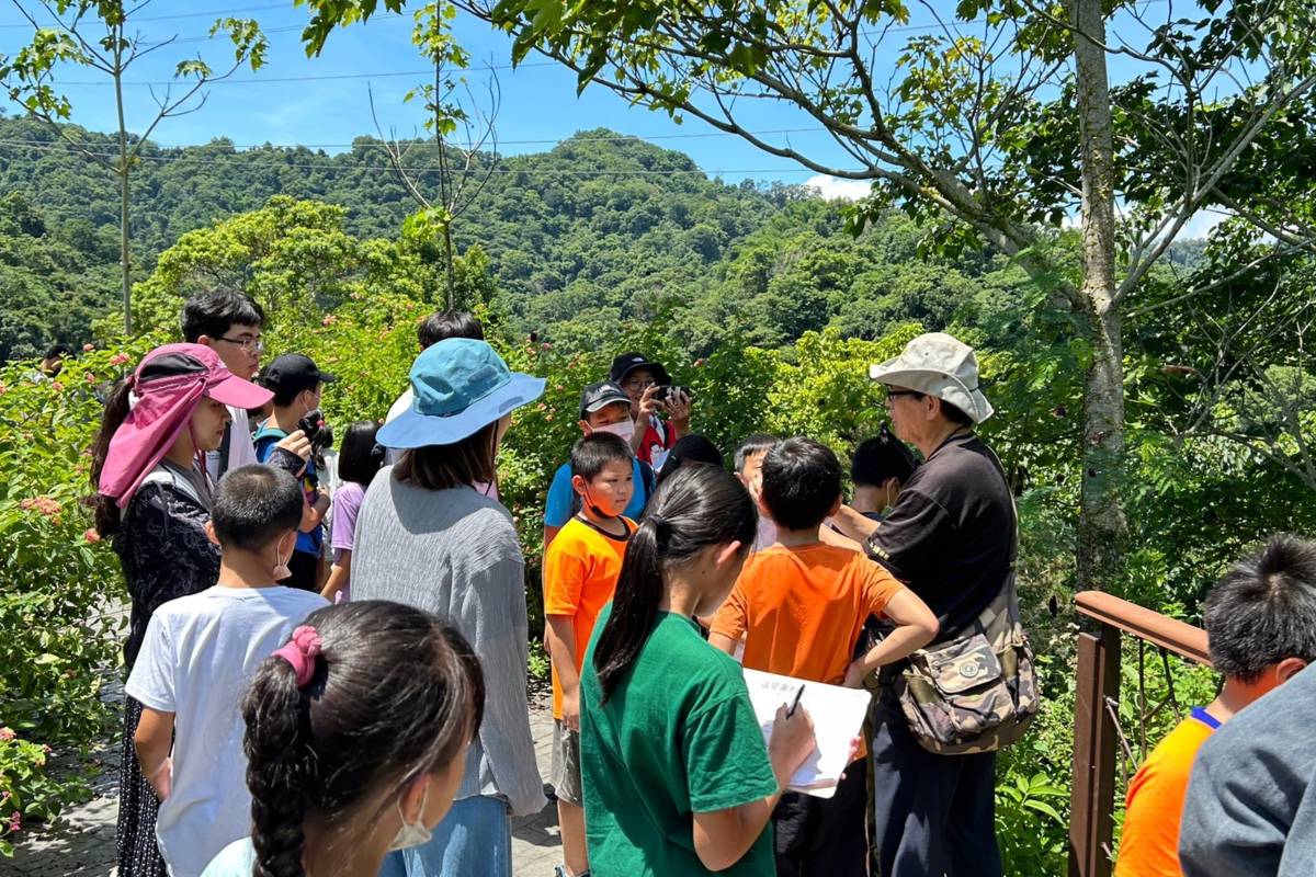 學童聆聽並記錄導覽員介紹的植物