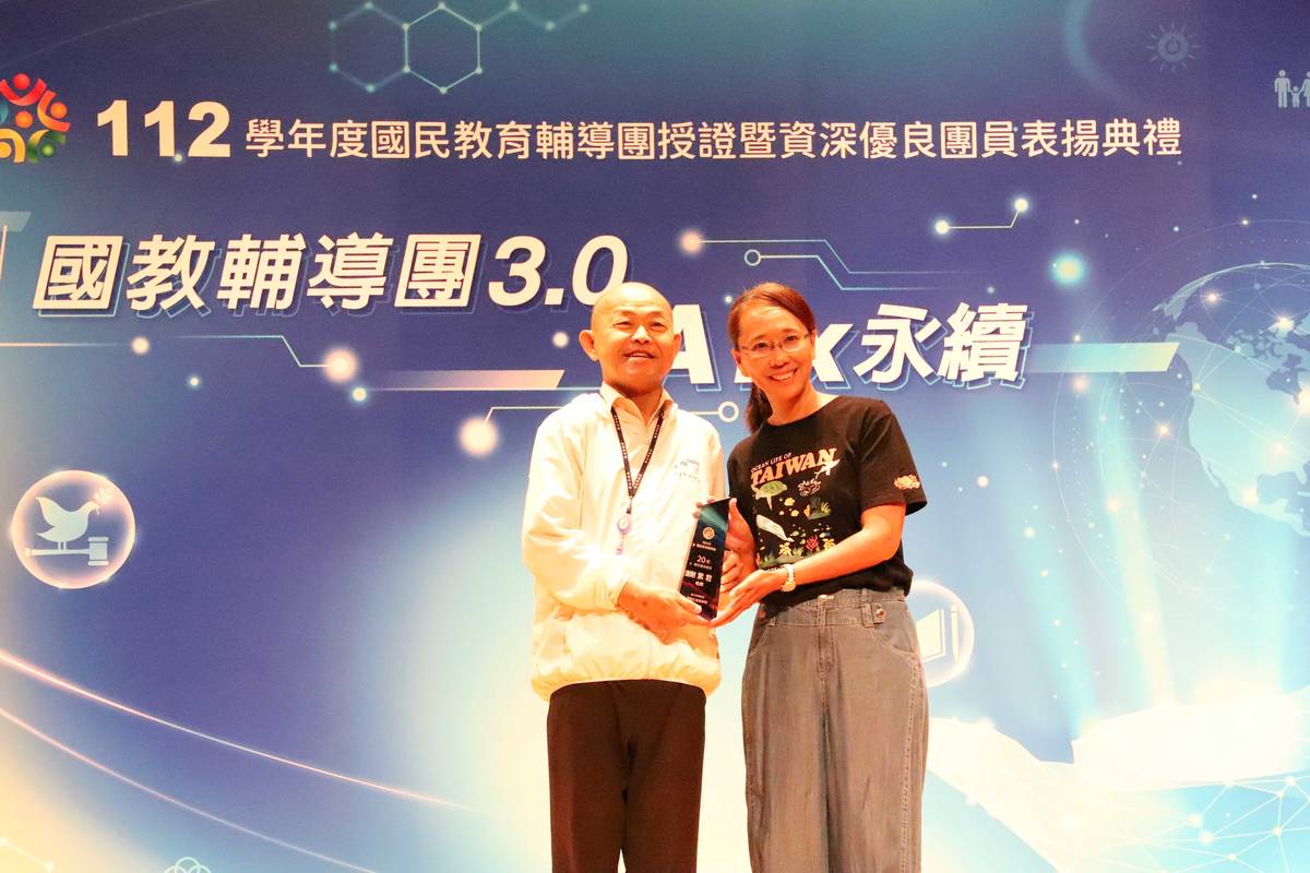 國小社會團專任輔導員謝素君(右)獲20年資深優良表揚，教育局歐人豪副局長(左)