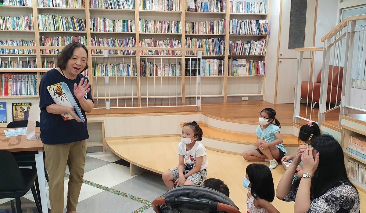 新店區安坑樂齡學習中心玉華志工(左1)於家長日在共讀站帶繪本說故事活動