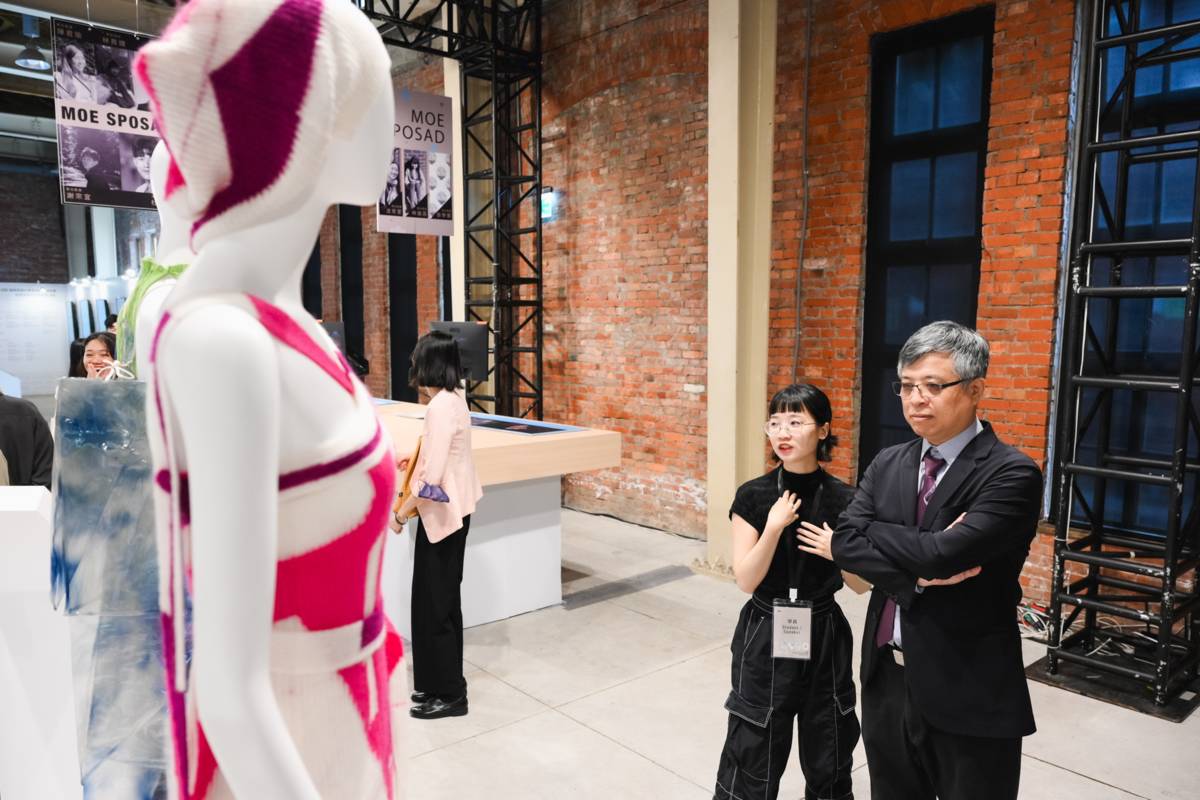 時尚設計組林育婕學員向教育部次長劉孟奇介紹自己的作品 