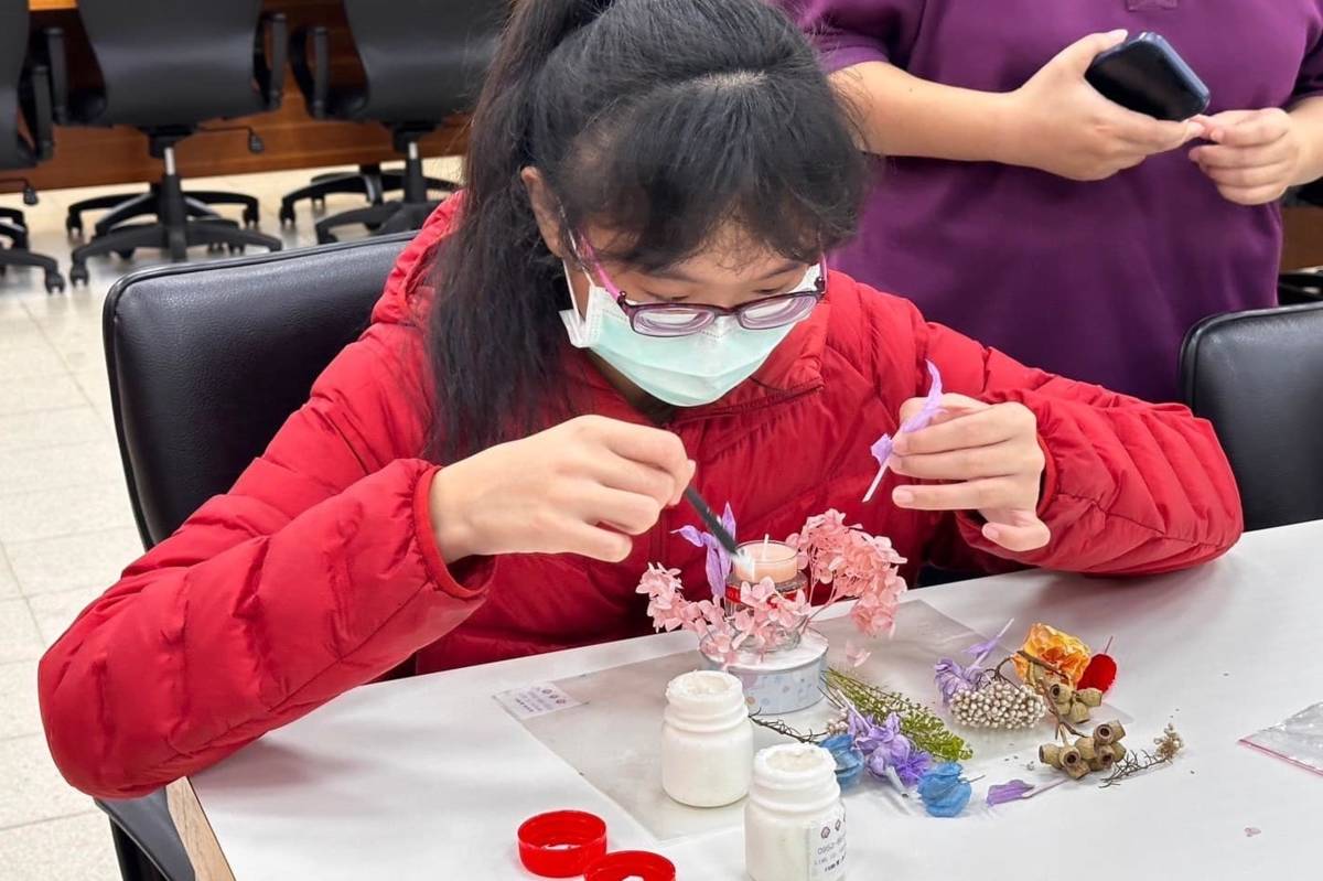 臺北啟明學校學生依花材大小依序插入底座，創作出獨一無二的花藝作品