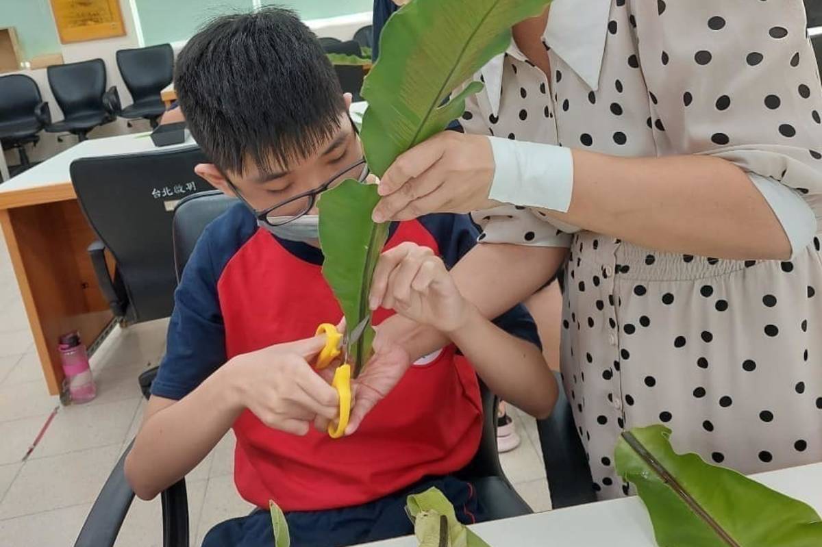 啟明教師帶著學生用剪刀處理各種花材