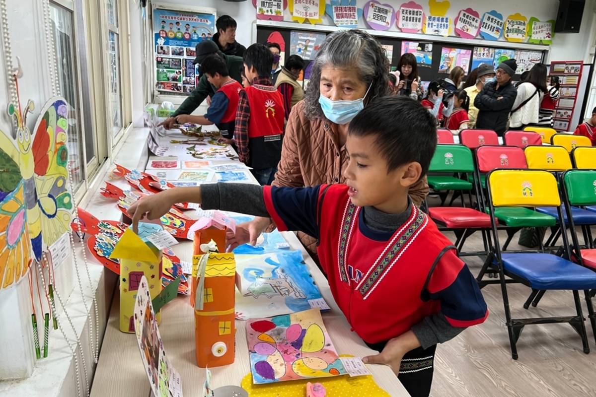 學童向家人介紹作品