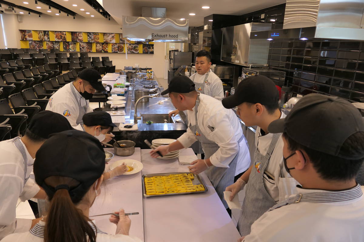  醒吾科大餐旅系朱俊松老師(右後4)帶領創意料理社學生準備餐點 (醒吾提供)