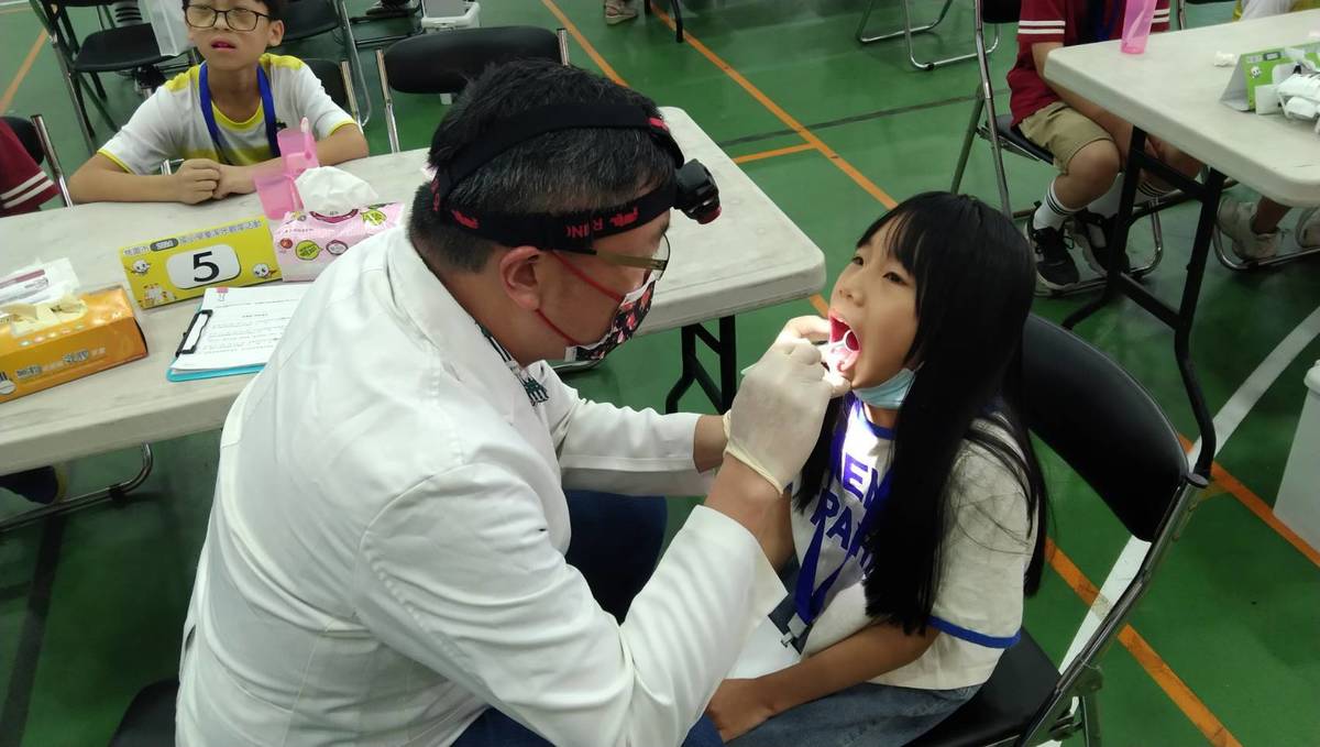 牙醫師檢查學生牙齒