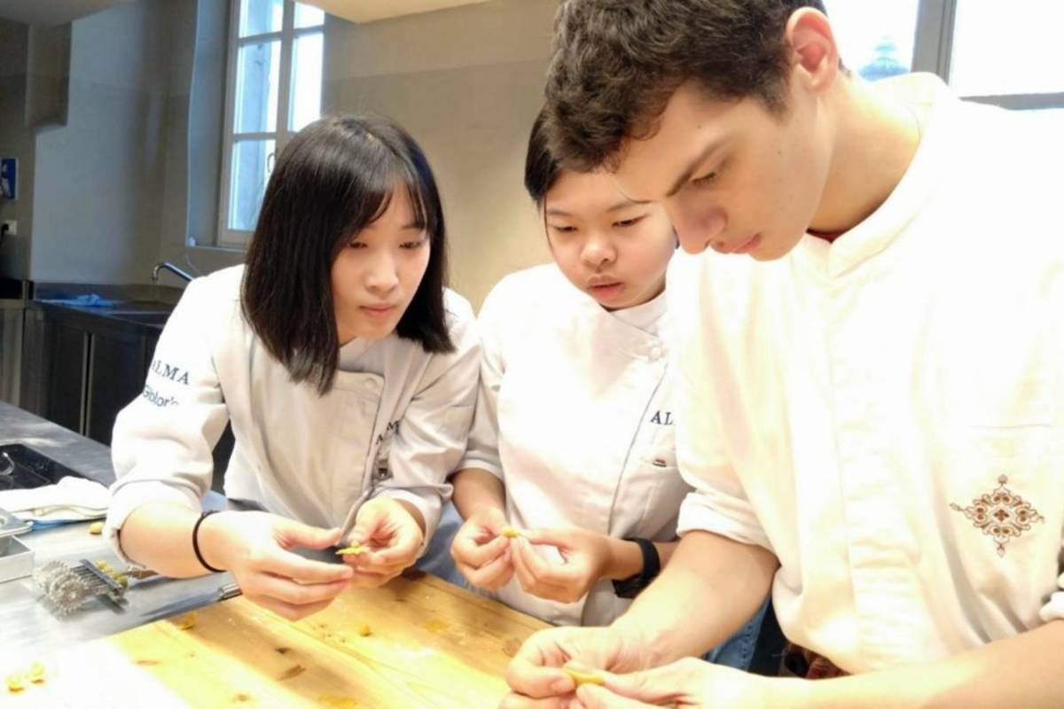 弘光科大學生蔡欣倚（中）在ALMA廚藝學院學習義大利麵點製作。（圖:弘光科大提供）