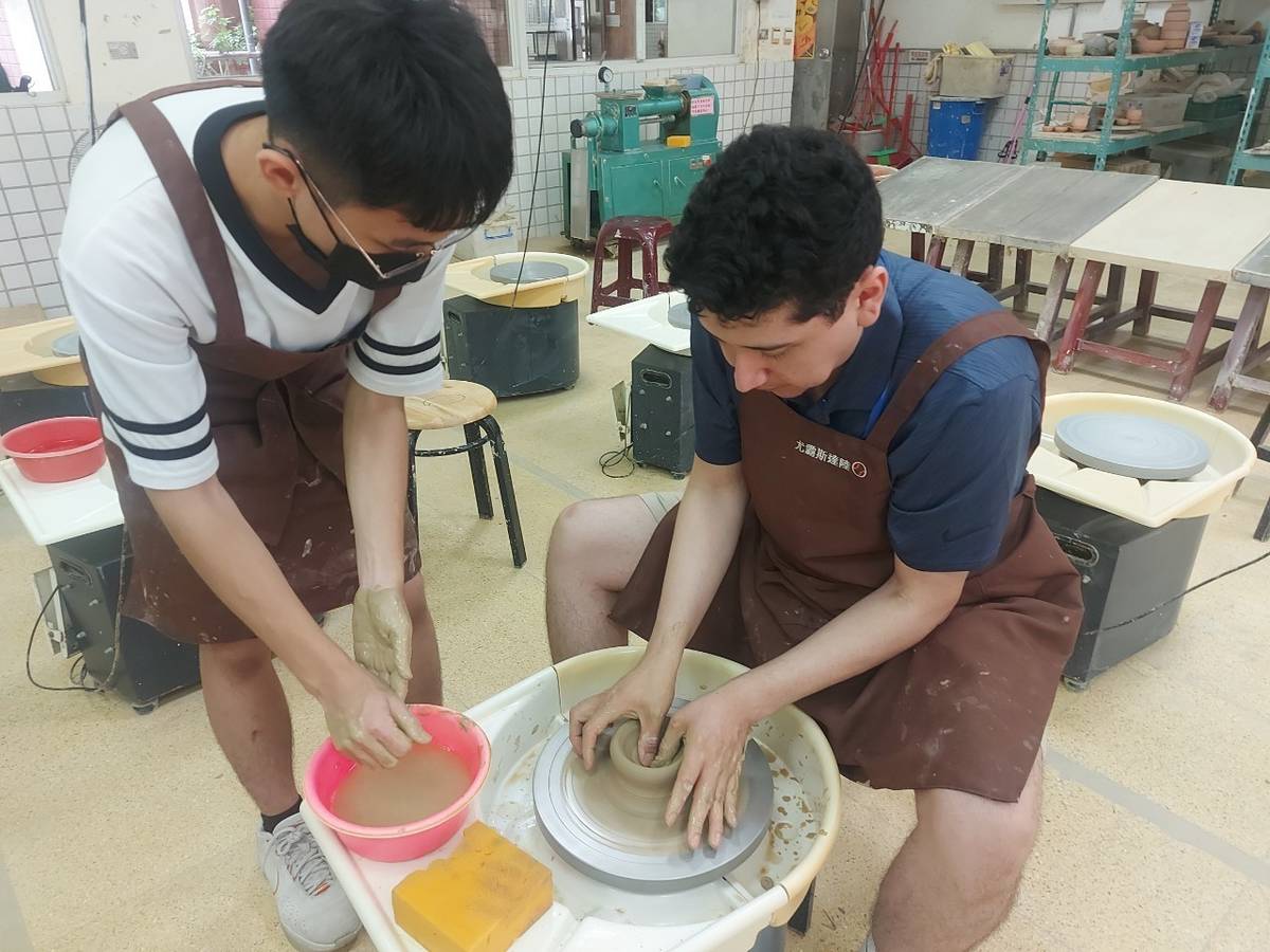 鶯歌工商學生(左)用英文一對一教美國學生(右)如何製作專屬陶器 (新北教育局提供)