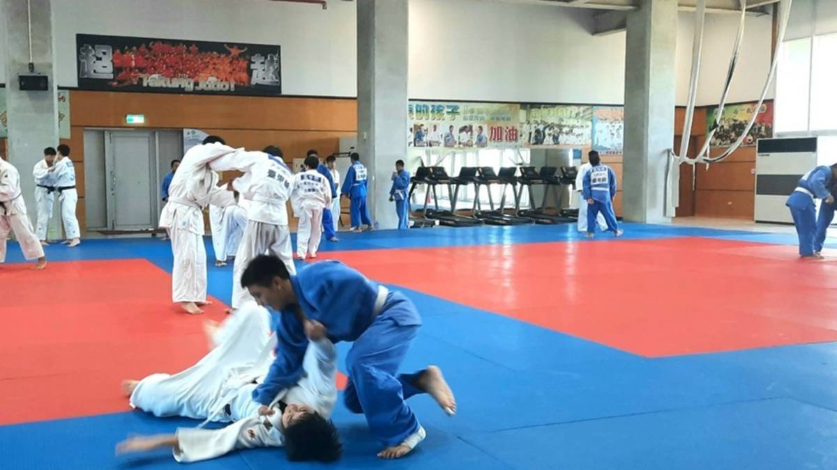 體育館中，來自各縣市的選手兩兩一組，在柔道墊上揮汗過招
