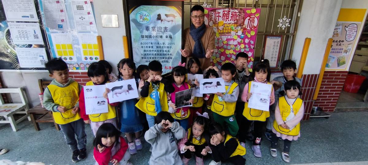 龍岡國小校長與同學們頒發畢業證書給校豬來福。(龍岡國小提供)
