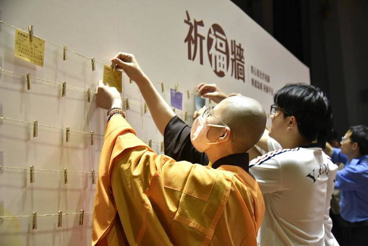 與會貴賓與僑生同學們將祈福卡掛上祈福牆 (僑委會提供)