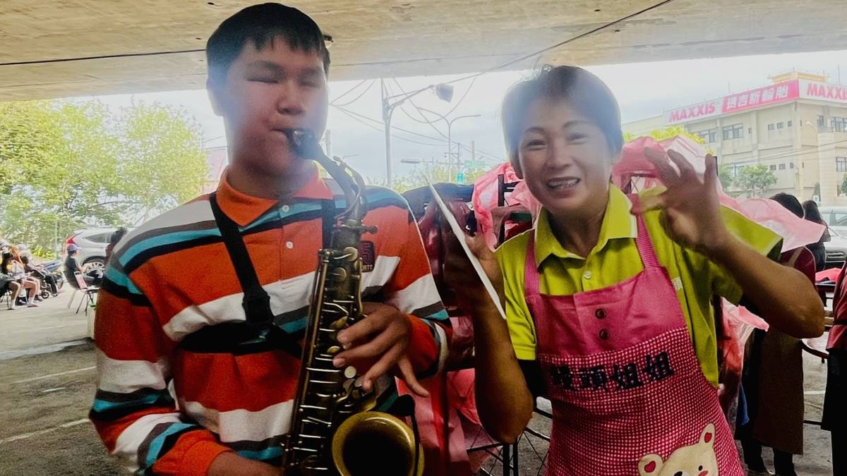 饅頭夫婦到學校分享愛而感動了視障生，自動到饅頭愛心站吹薩克斯風和大家分享愛。