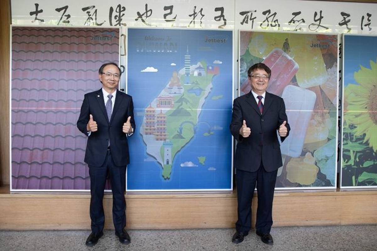 興大校長詹富智（右）與泓瀚科技董事長呂椬境（左）簽署產學合作備忘錄，後方為展示的彩色太陽能板。