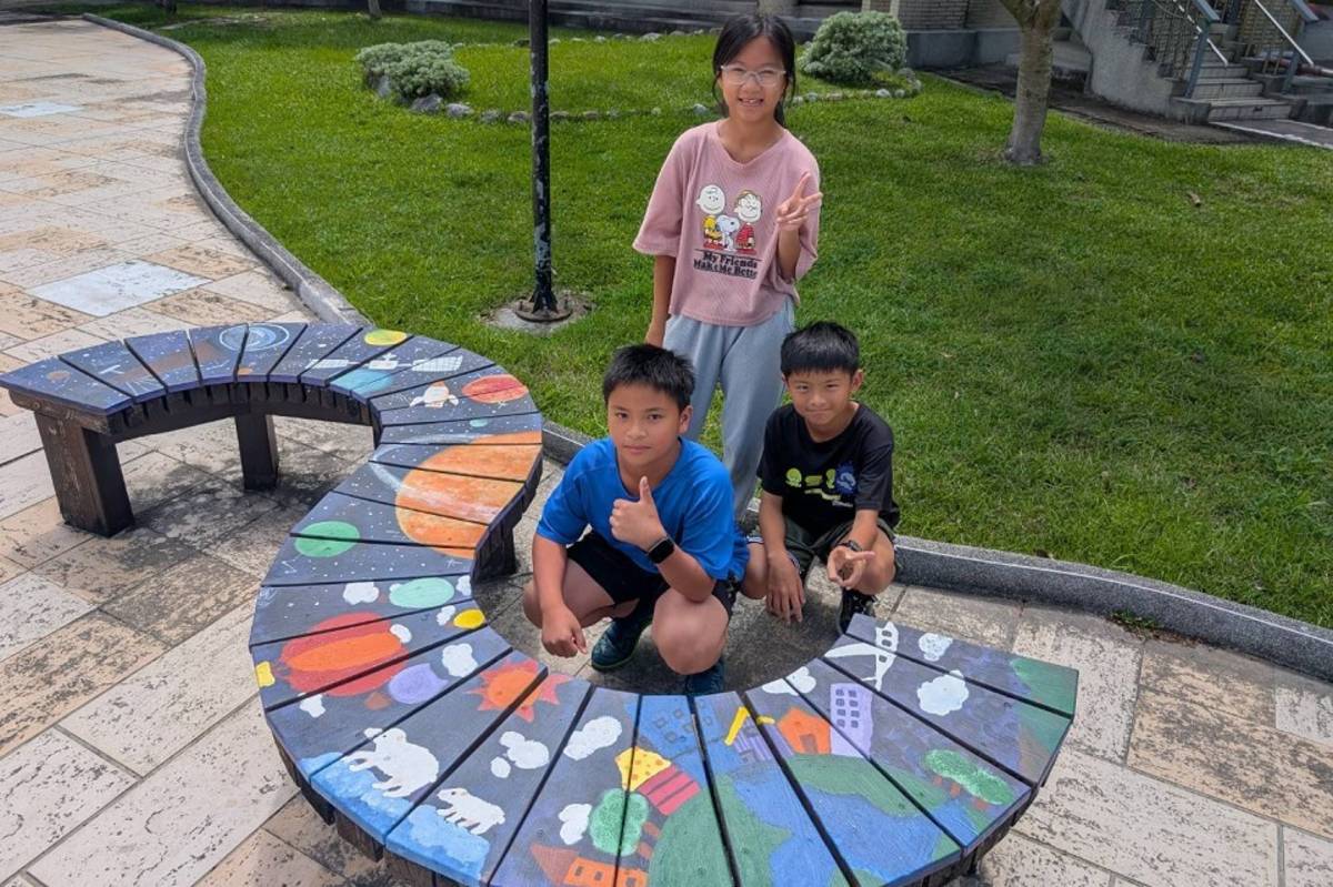 學童與彩繪的椅子合影