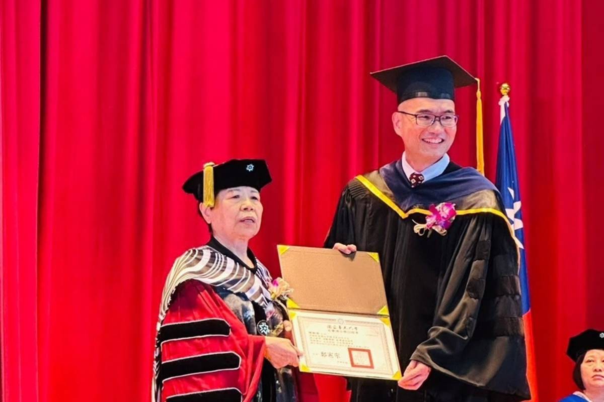 國立臺東大學校長鄭憲宗(右)將名譽博士學位頒授給愛心菜販陳樹菊(左)。