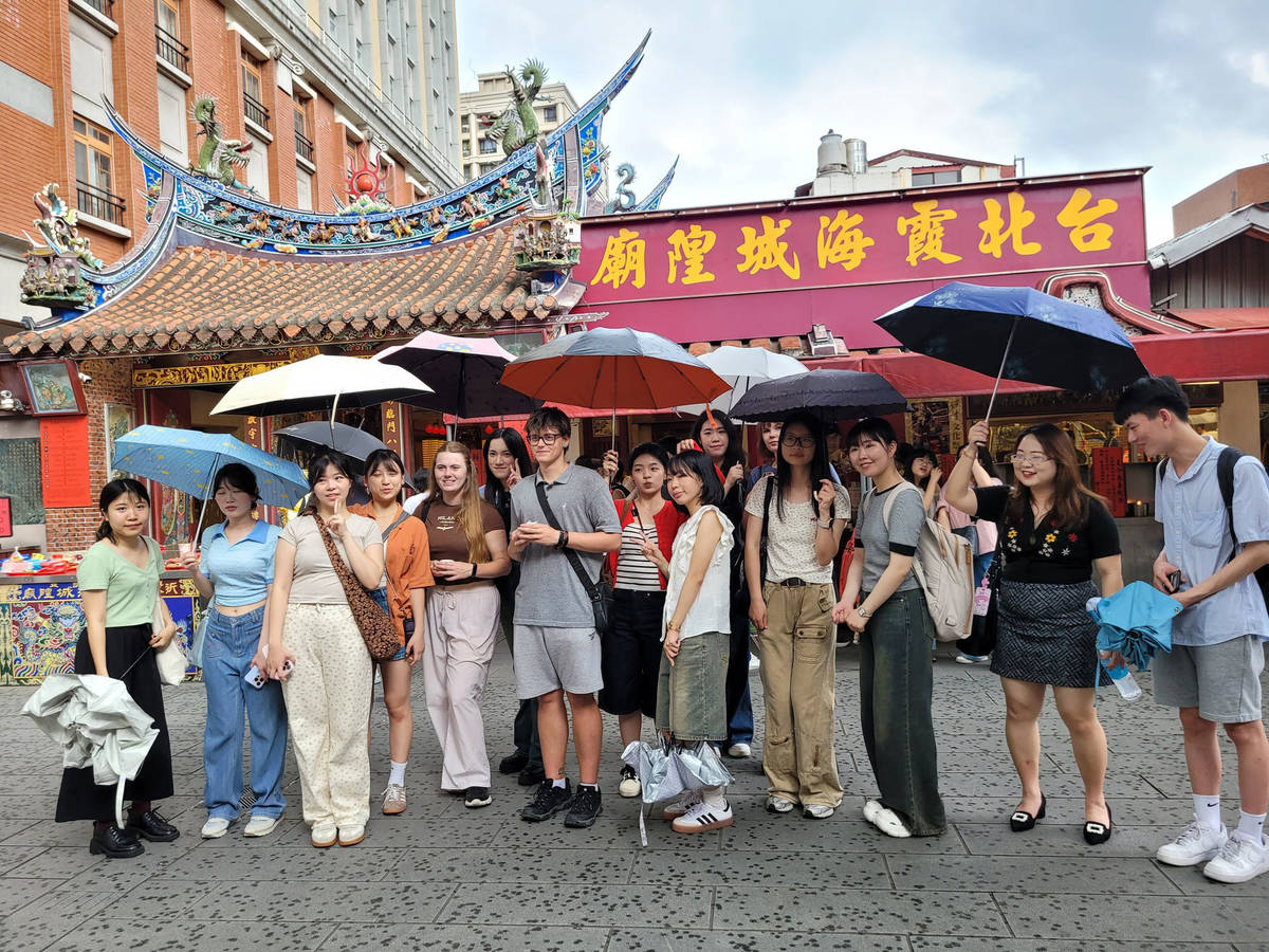 世新大學國際學生參訪霞海城隍廟，體驗求籤等台灣信仰文化。(世新大學提供)