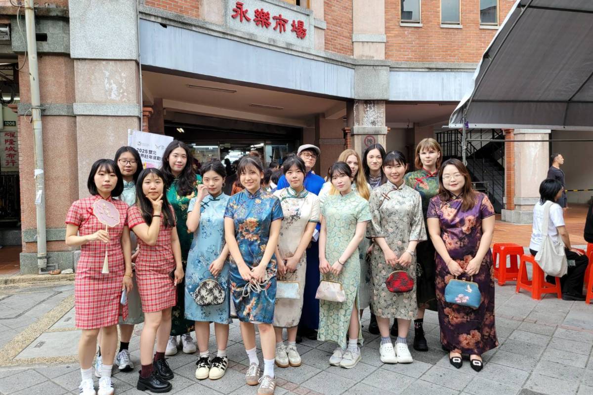 世新大學國際學生穿旗袍遊大稻埕老街。(世新大學提供)