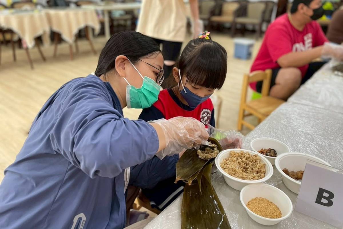 孩子實際動手將食材包進粽子裡 (教育部提供)