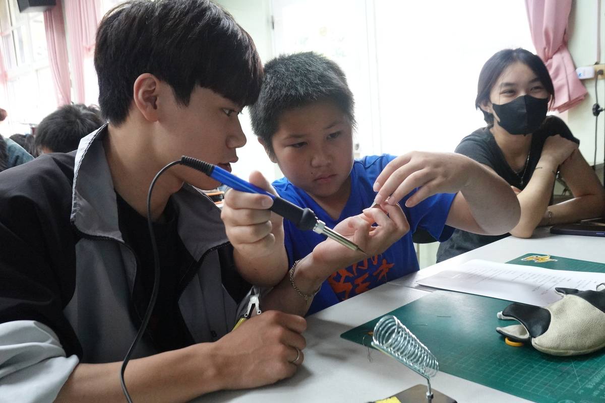 大學生在「DIY創客」課程輔導小學生焊接（圖源：僑樂國小）