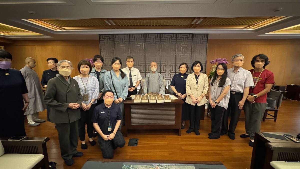 國臺圖館修復團隊曹翠英館長（右4）、曾添福顧問（右2）、吳英美師姐（右5）與慈濟證嚴法師合影。(國臺圖提供)