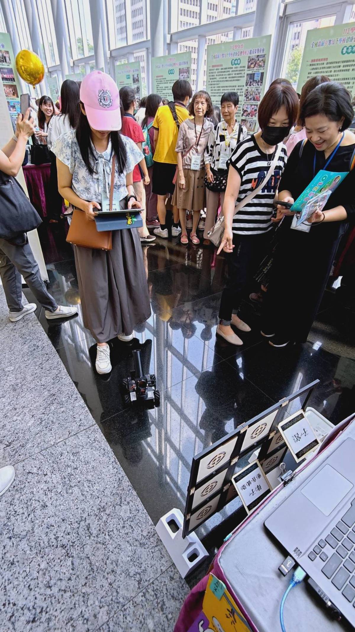 健康促進學校成果展現場，民眾體驗機器人玩九宮格遊戲。