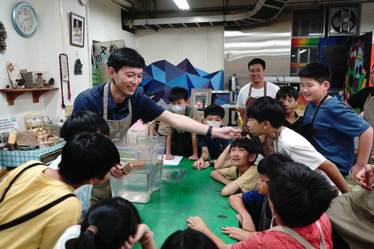 北科大、政大實小合作「城市蜂巢」木工營隊，北科大李昊哲老師引領學生辨識木材。(北科大提供)