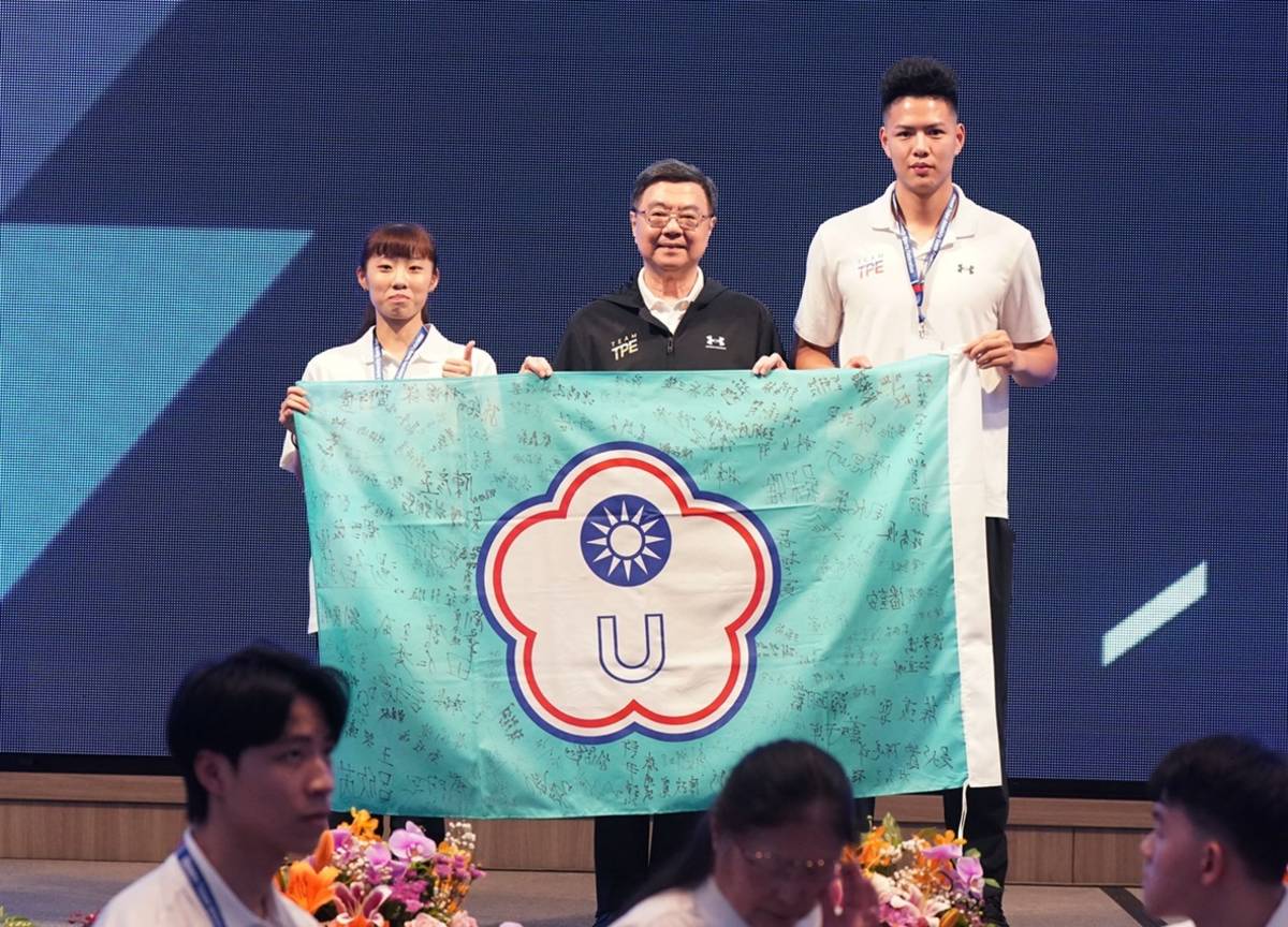 2025第32屆萊茵魯爾世界大學運動會感恩餐會，由跆拳道品勢郭彥妤選手(左)及羽球吳軒毅選手(右)致贈簽名團旗予行政院卓榮泰院長(中)。