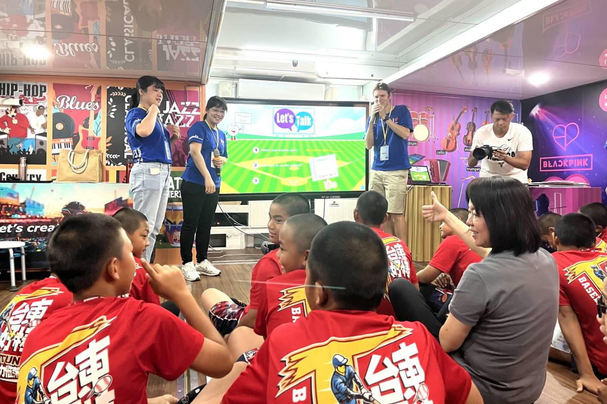 臺東縣教育處長蔡美瑤與紅葉國小棒球隊一起體驗由AI輔助創作歌曲，過程中，和學生一起與外師互動。