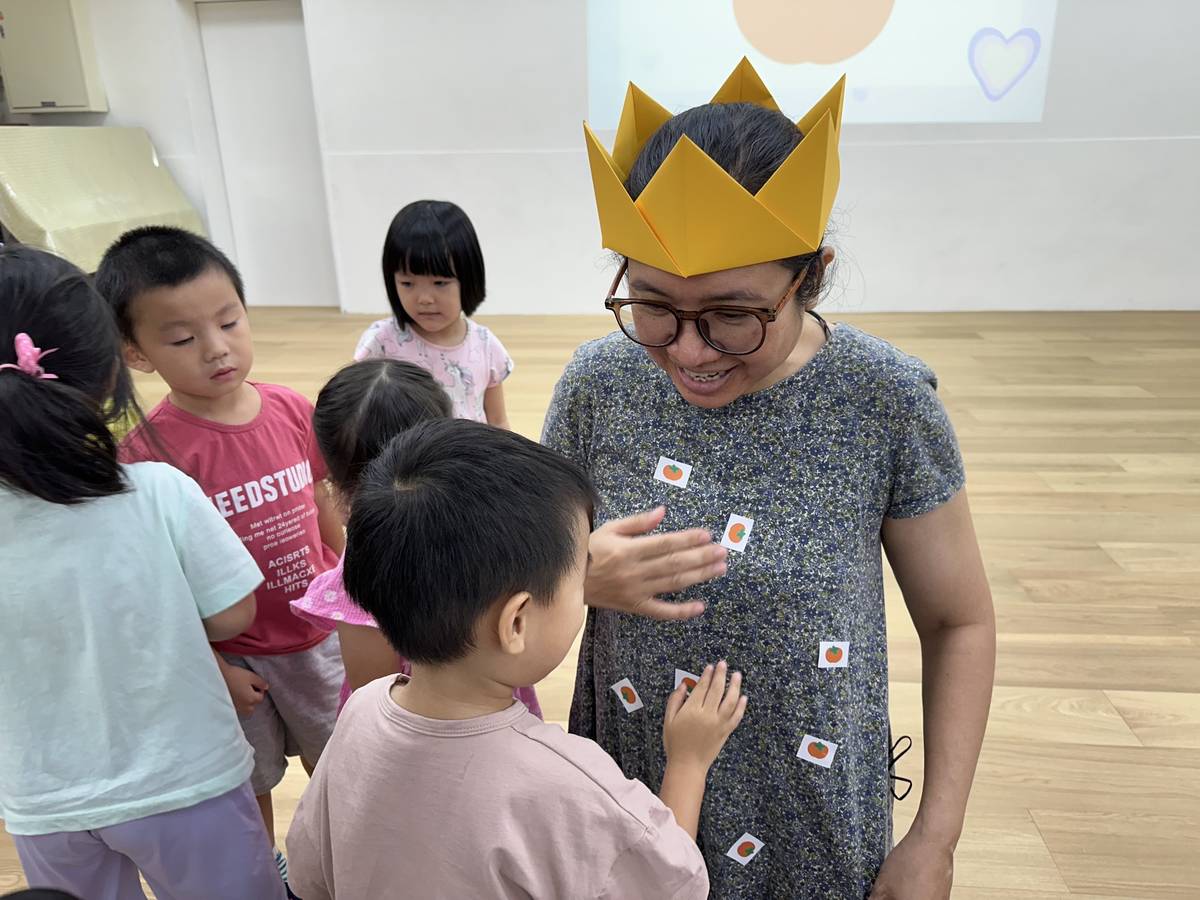 育航幼兒園小朋友將「柿子貼紙」貼在老師身上，表達感謝