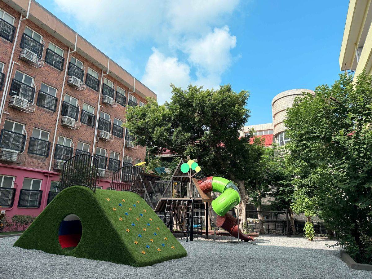 遊戲場以圓角礫石為環保鋪面，有孩子最喜愛的盪鞦韆、兩層樓高的雲端滑梯和許多攀爬遊具