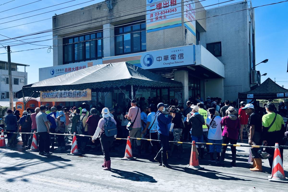 行政院一站式服務平臺協助災民申請相關補助，民眾排隊等待。(行政院提供)