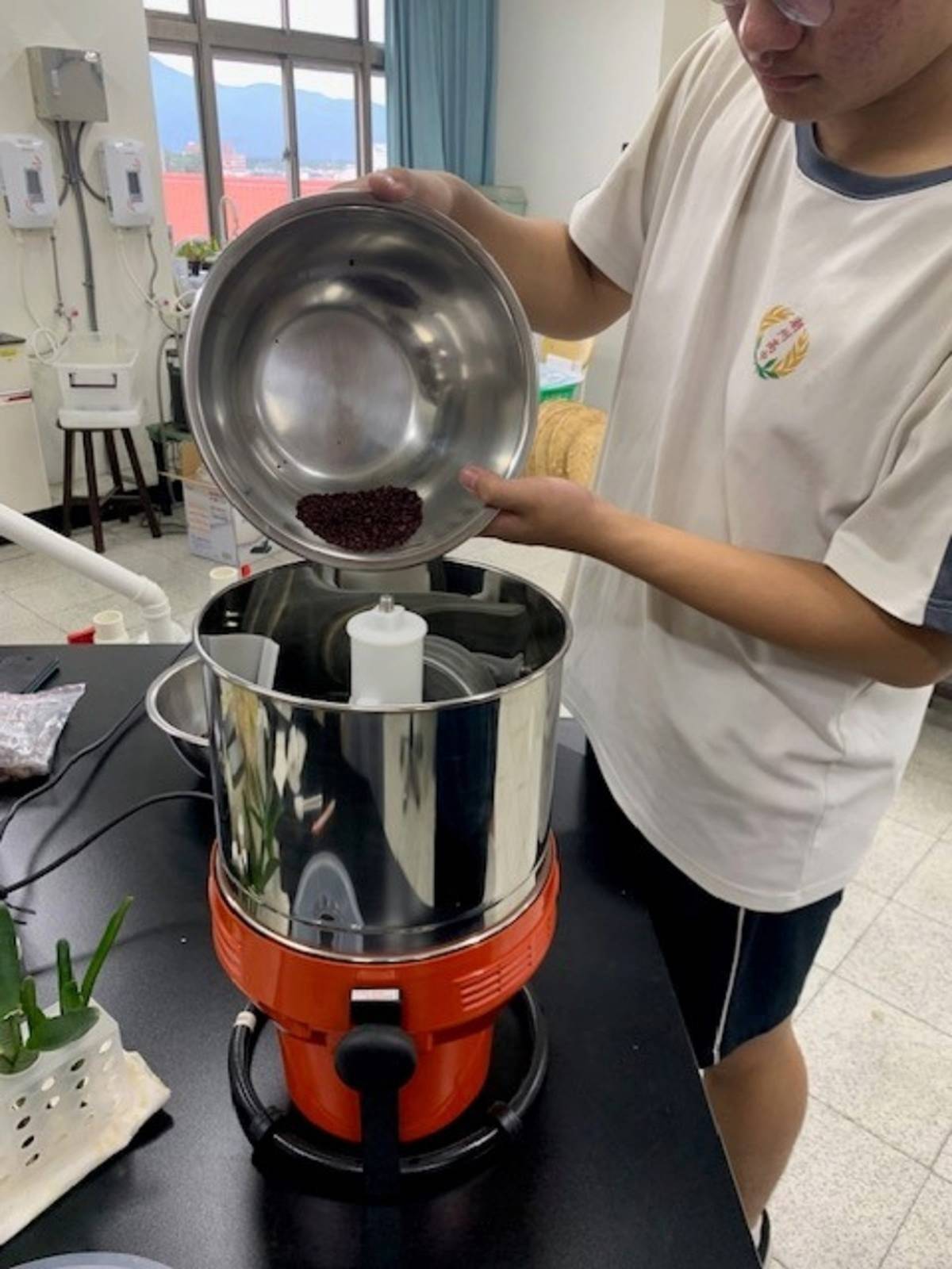 潮州高中學生使用研磨機研磨豆仁碎片