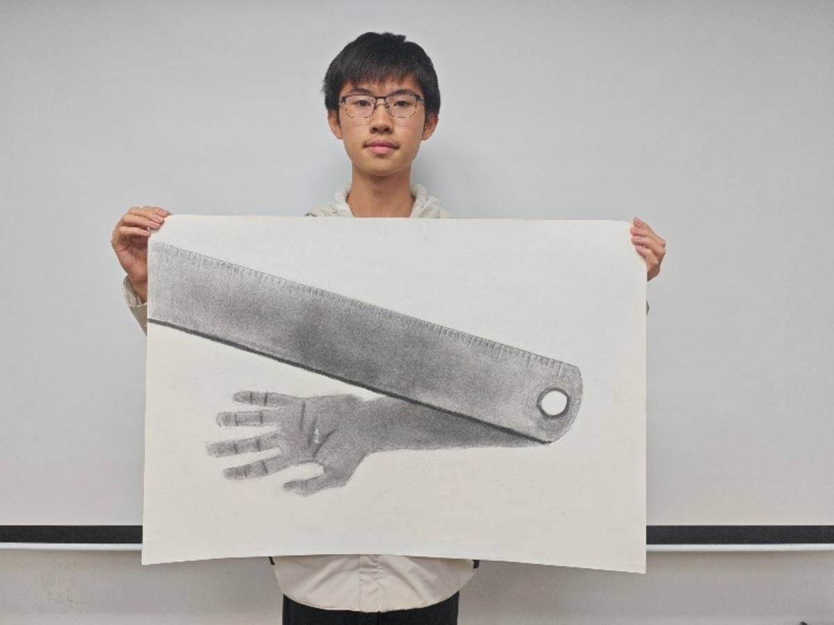 學生張宸豪畫了一隻尺以及一隻手，尺象徵的是規矩，而手代表著在與規矩拉鋸的自己