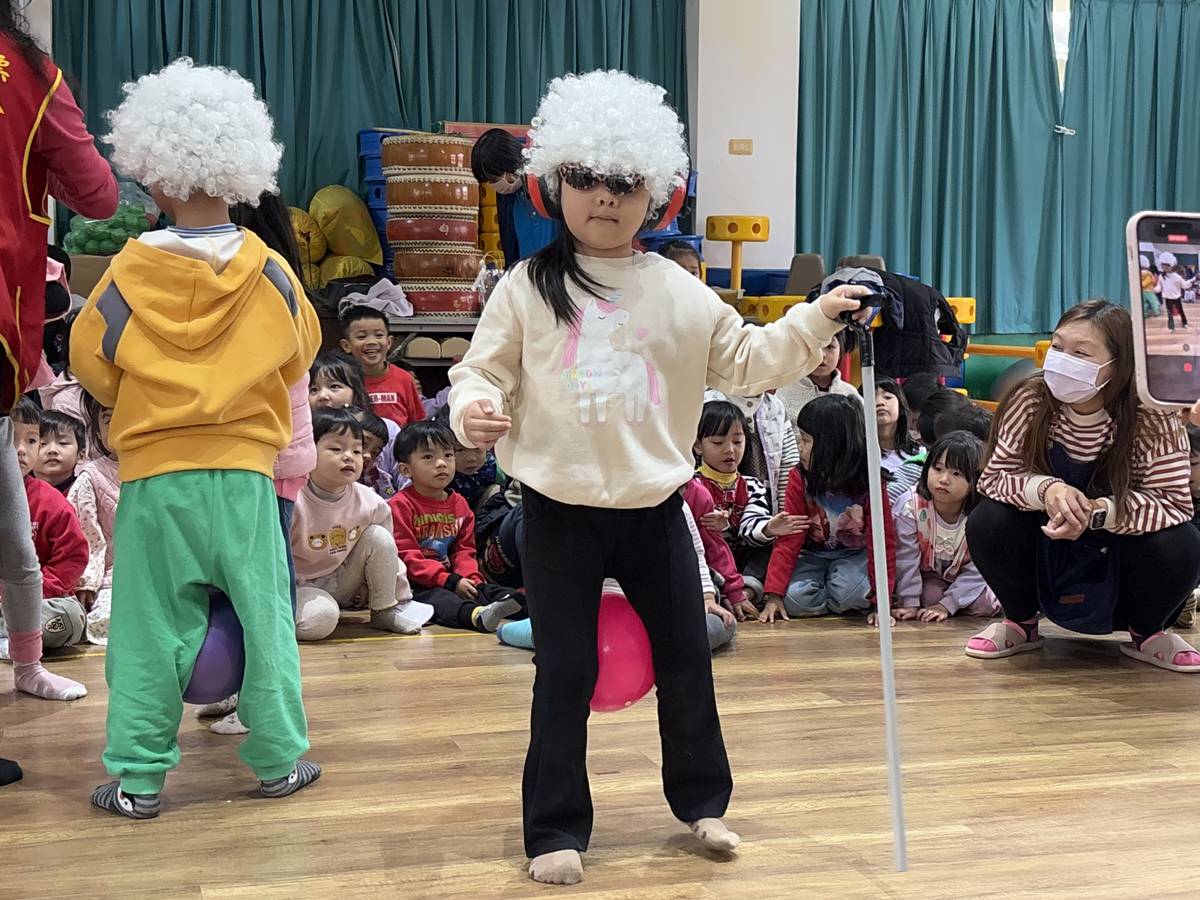 小朋友戴上白色假髮、耳罩，拿拐杖體驗長者的不便