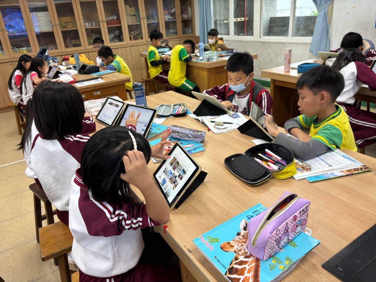 南門國小學生運用平板電腦查詢資料，進行專題報導的準備 