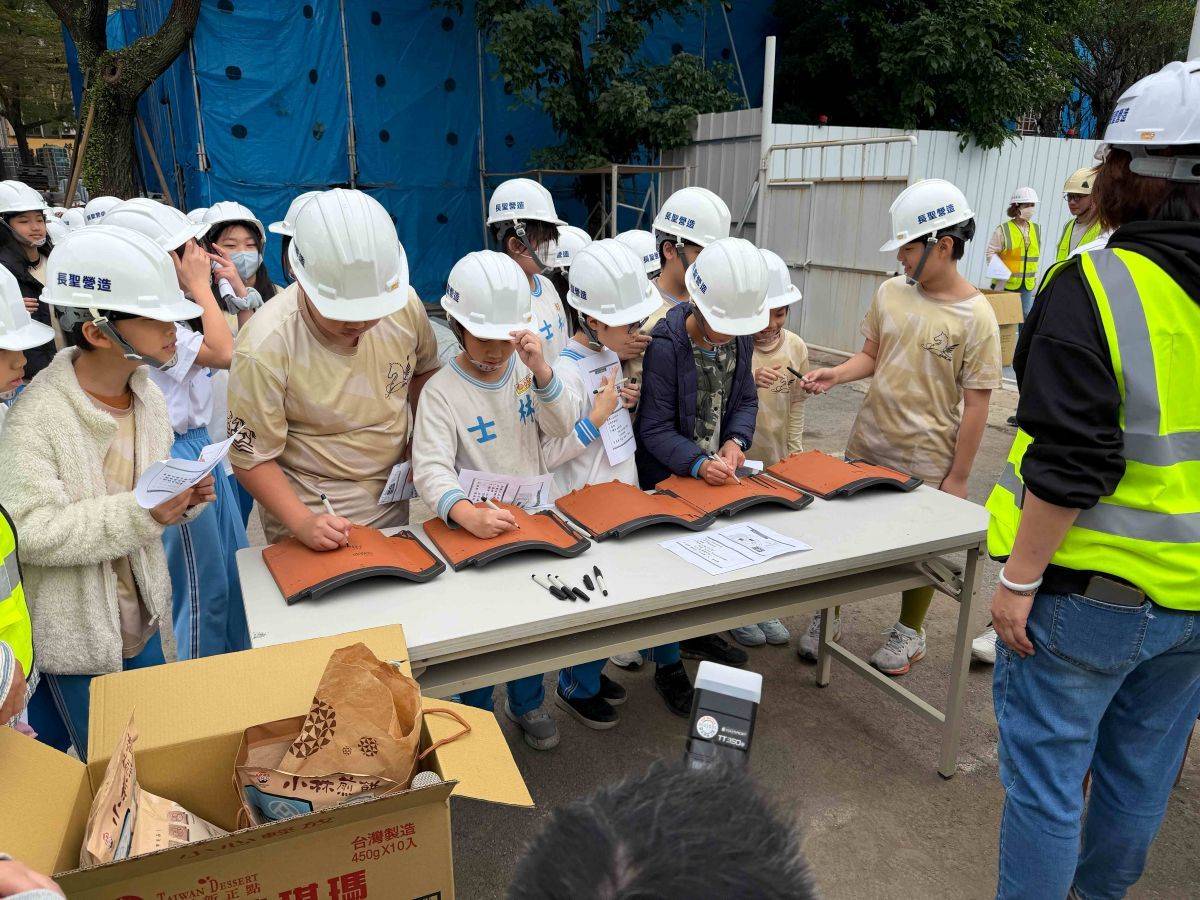 師生們在新的屋瓦上簽名並寫下祝福，祈願工程順利