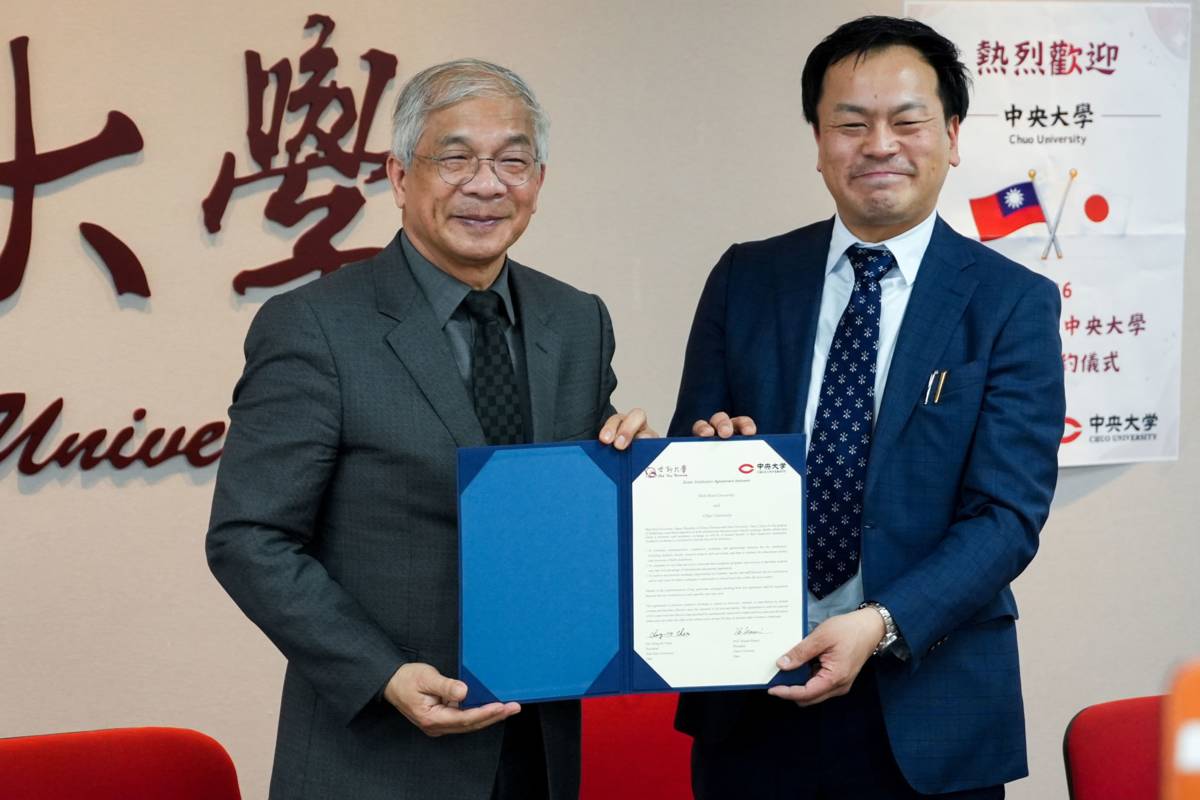 世新大學校長陳清河（左）與日本中央大學國際中心松永伸也（右）交換姊妹校合作協議。(世新大學提供)