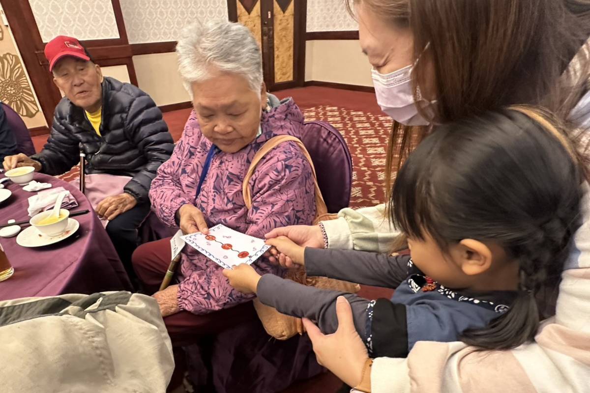 幼童將祝福小卡傳遞給長輩